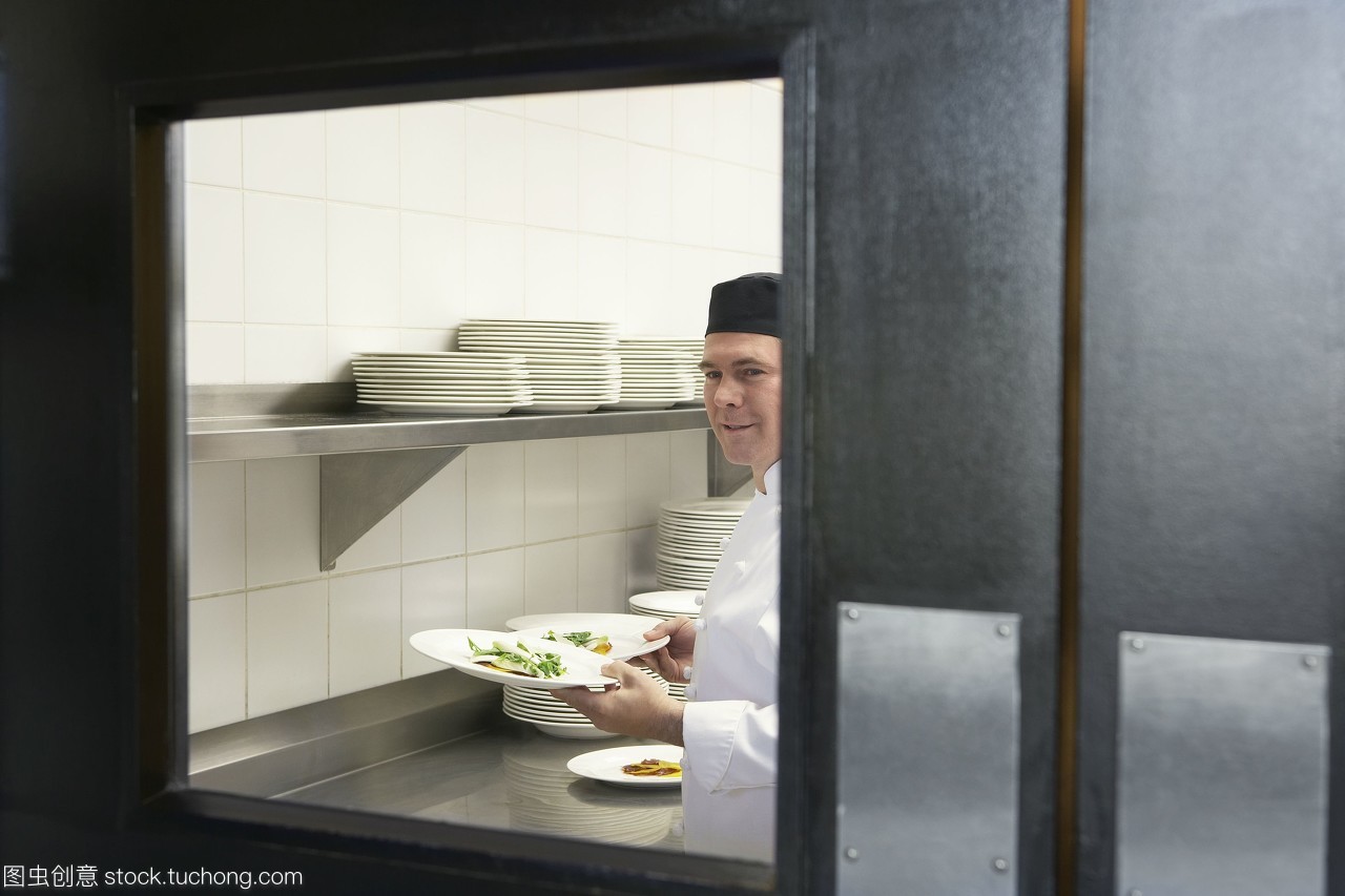 專業廚房中的熱情服務 微笑廚師與精美正餐